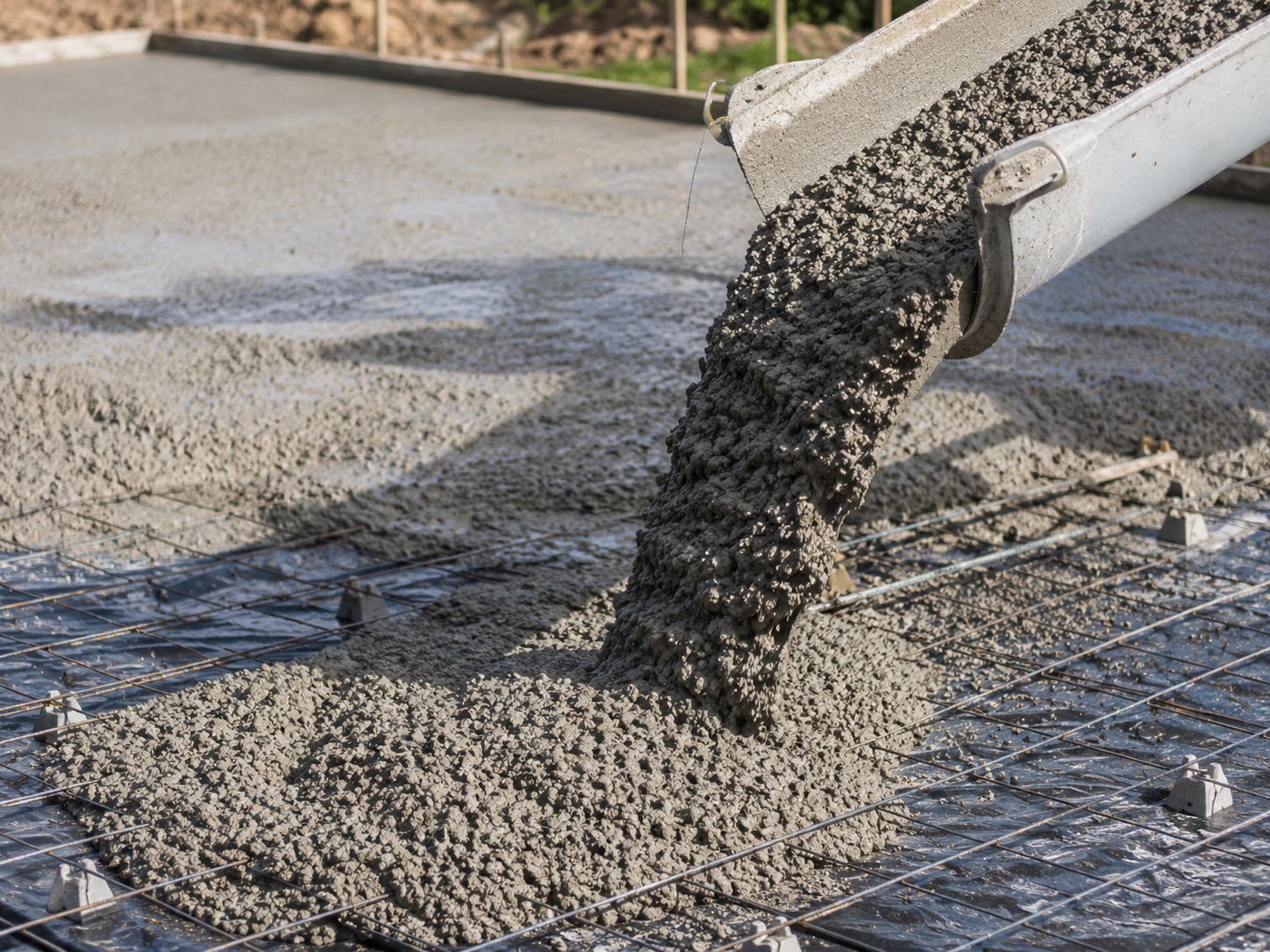 Placing concrete for a reinforced foundation on prepared ground